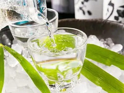 氷の入ったグラスに焼酎を注いでいる様子